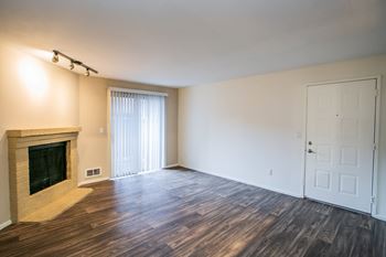 Spacious Model Apartment Living Room with Vaulted Ceilings Faux wood flooring and Fireplace in Bellevue Apartments